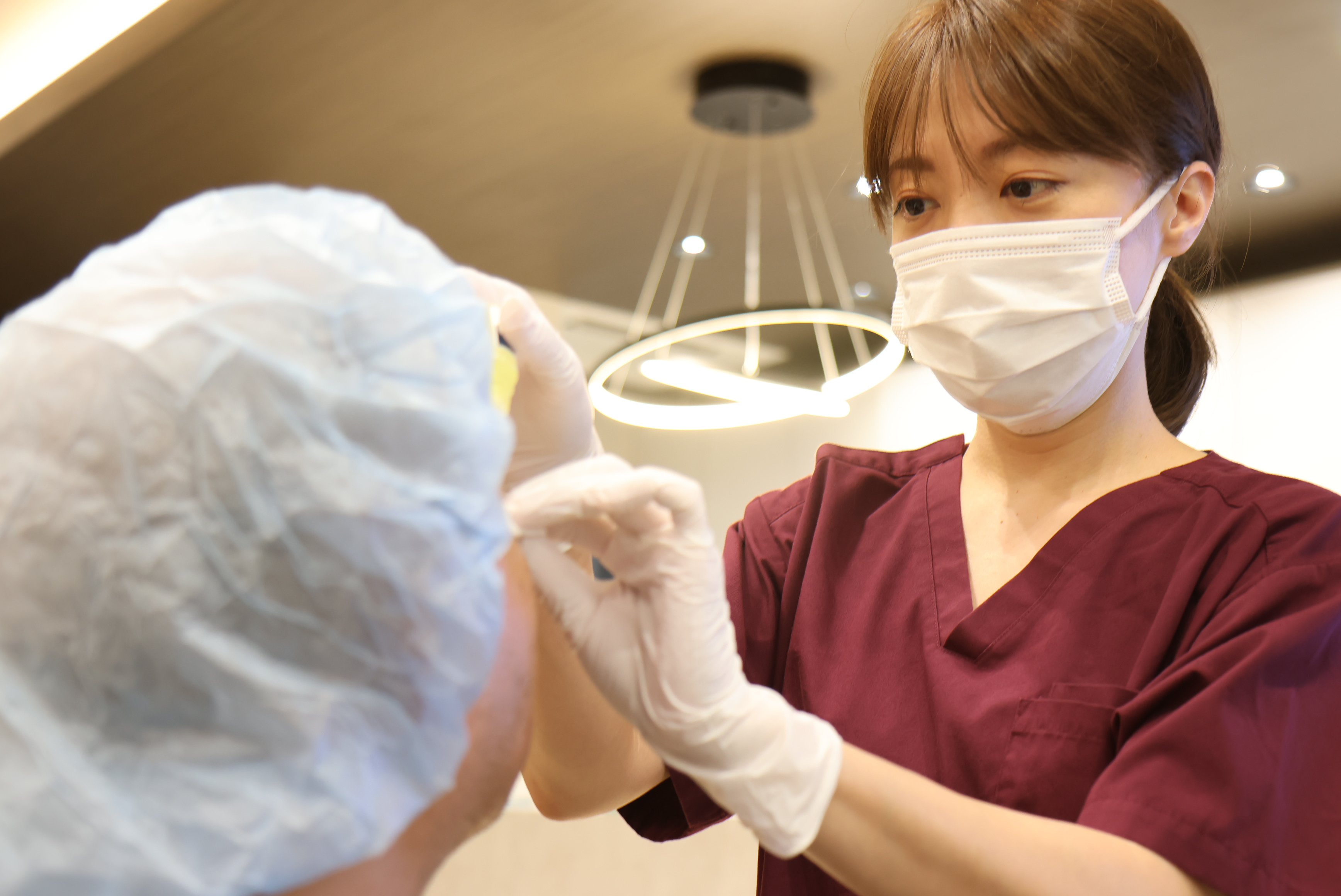 受付･検査補助先輩スタッフが点眼している写真